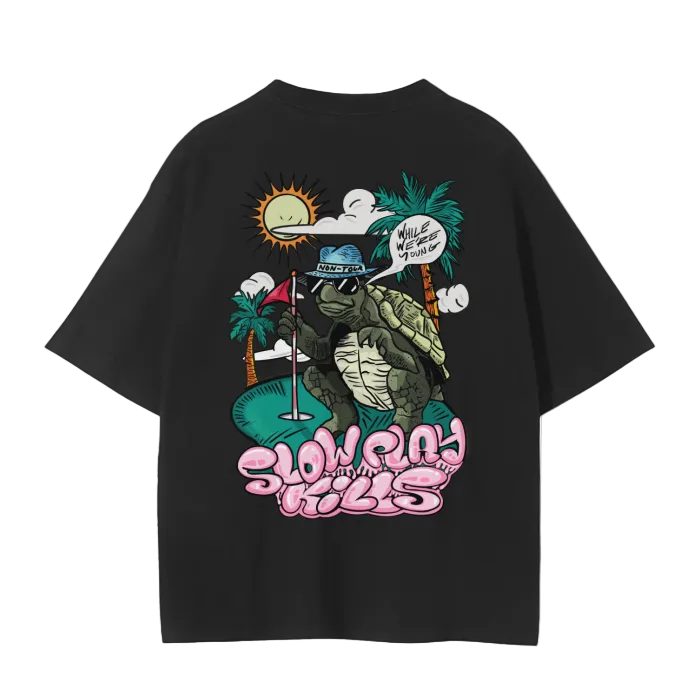 A white crew neck t-shirt with a graphic print of a turtle in a sun hat and sunglasses, playing a game of golf, and the text 'SLOW PLAY KILLS' below it.